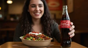 Smiling customer holding Mexican Coca-Cola at Chipotle restaurant