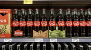Store shelf with Mexican Coca-Cola glass bottles labeled Hecho en México